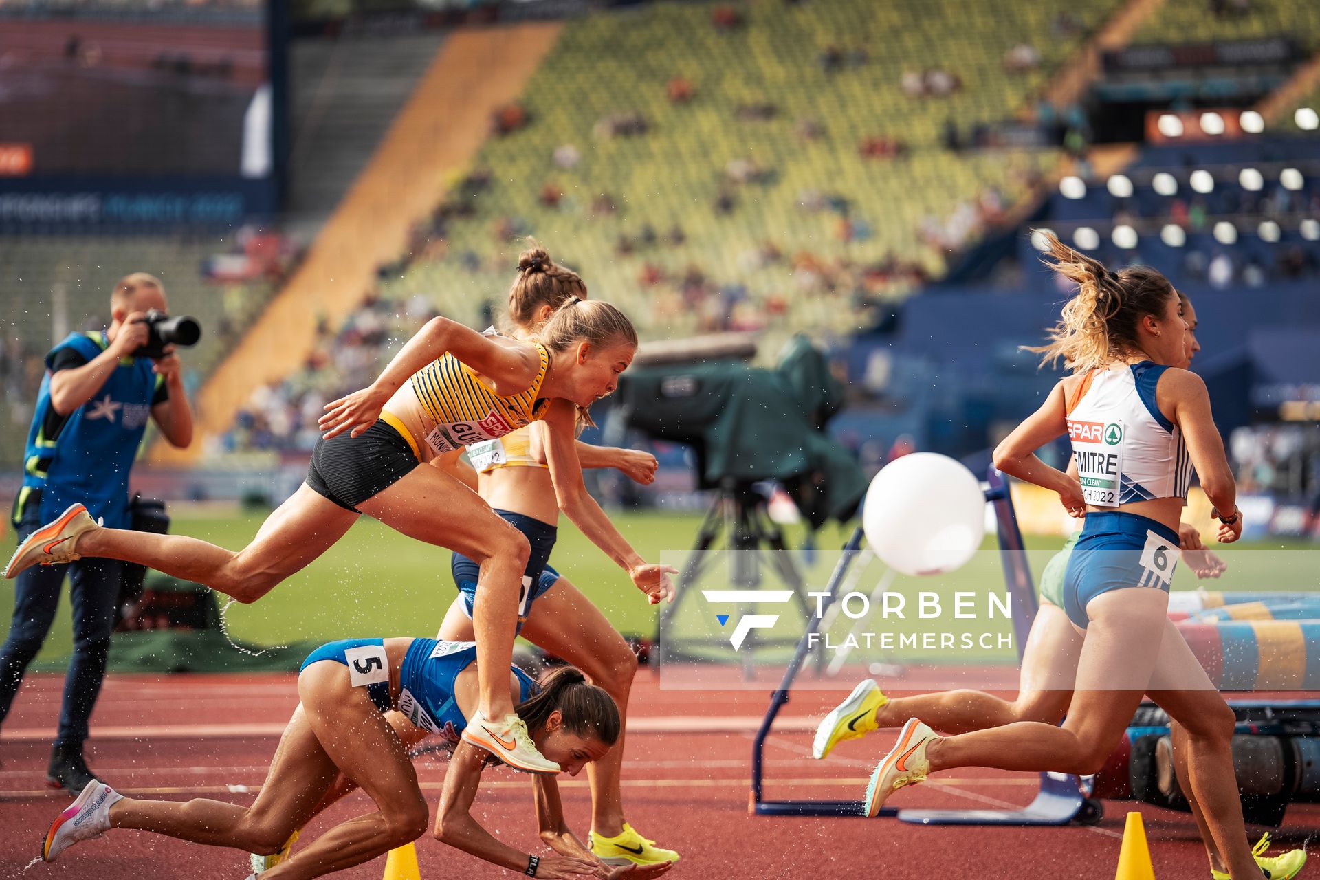 Olivia Guerth (GER) muss ueber Martina Merlo (ITA) springen, die gestuerzt ist im 3000m Hindernis Vorlauf am 18.08.2022 bei den Leichtathletik-Europameisterschaften in Muenchen