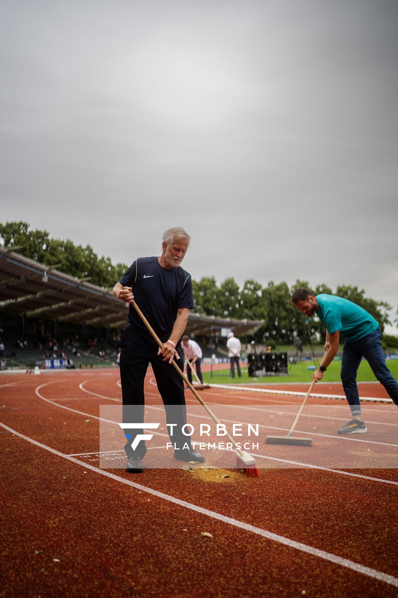 Helfer fegen die Bahn am 01.07.2023 waehrend den deutschen U23 Leichtathletik-Meisterschaften im Jahnstadion in Göttingen